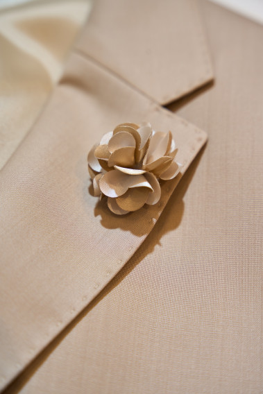 Costume SUAT beige sable. Gros plan détail sur le pin fleur beige