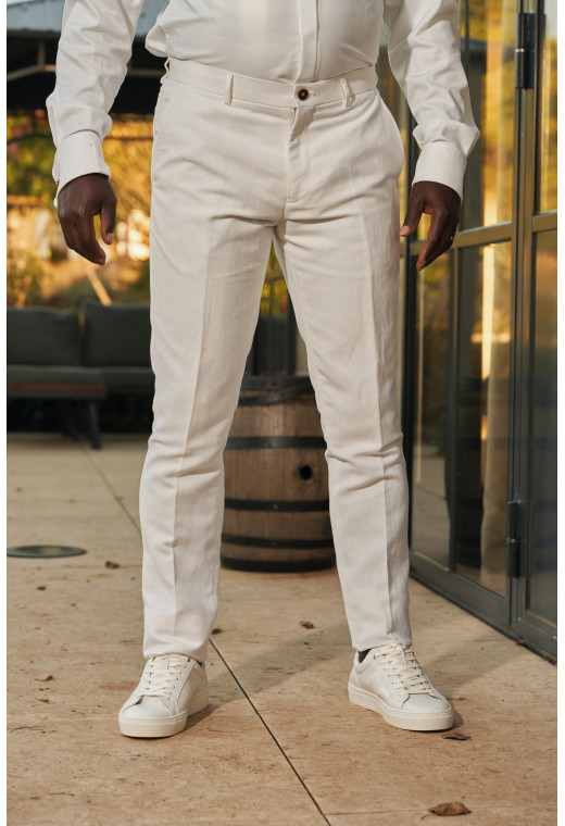 Homme portant le pantalon LINCOLN blanc. Il comporte 3 poches avant et 2 poches arrière.